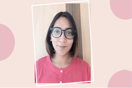 Profile pic of a woman with short hair, spectacles, wearing pink framed in light and dark pink  