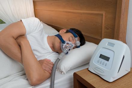 A man sleeping with a CPAP machine attached to his face