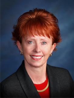 Profile picture of red haired Cindy in a red shirt and black jacket  