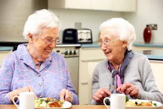 2 elderly women at a kitchen table 