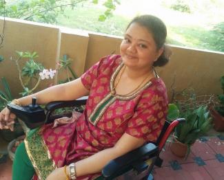 Aarthi Sampath, with limb girdle muscular dystrophy happy and contented on her wheelchair