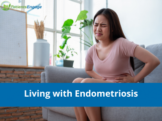 Stock pic of a young woman in a pink Tshirt holding her abdomen in pain due to endometriosis 