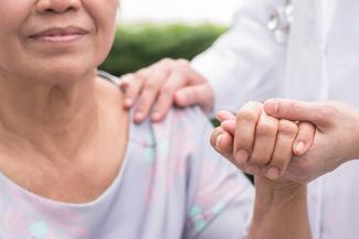 A stock pic of a woman being supported by a caregiver