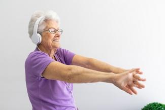 An elderly person listening to music and exercising