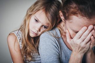 Stock pic of a young girl child with blond hair hugging her mother holding her face and feeling depressed. Image is respresentational only 