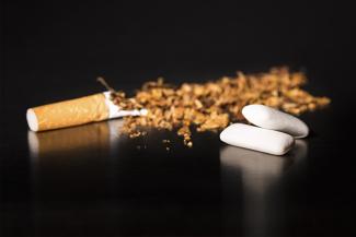 Image of a crushed cigarette and nicotine gum indicating tips to quit smoking 
