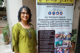Ritika Sahni in a green kurta on the left standing next to a Trinayini poster on the right
