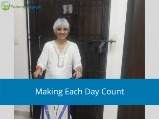 Usha Jesudasan in a white kurta standing in front of her door with an assistive device that helps her stay mobile. PatientsEngage logo on top left and Text overlay on blue band - Making Each Day Count