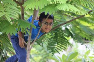 Omkar who has Congenital Adrenal Hyperplasia (CAH) climbing a tree