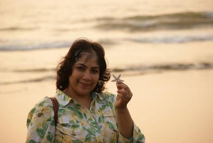 Picture of the author Smriti Joshi holding a starfish and set against the sea
