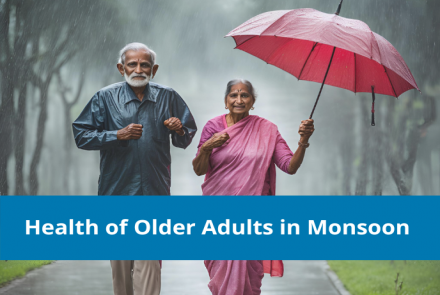 An elderly Indian couple holding a red umbrella walking in the rain and the text overlay on blue strip Health of Older Adults in Monsoon  