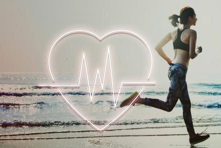 Stock pic of a young women running on the beach with an overlay of a heart and ECG 