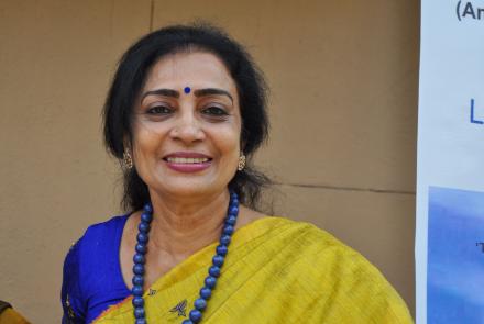 A woman in a blue blouse and a yellow sari 