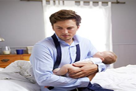 Image: A man with a baby in arms. Man looking depressed