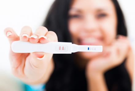A woman holding up the pregnancy test kit