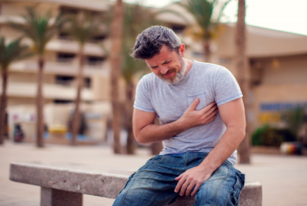 A man clutching his heart having a heart attack 