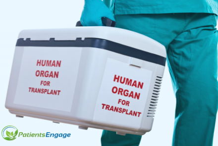 A medical worker in green scrubs and gloves carrying a white box with text that says human organ for transplant