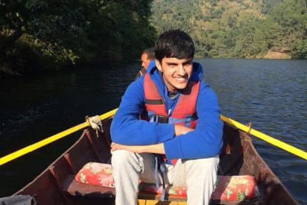 Image: Pranav, young autistic person on a boat in a river